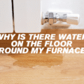 Why is there water on the floor around my furnace?